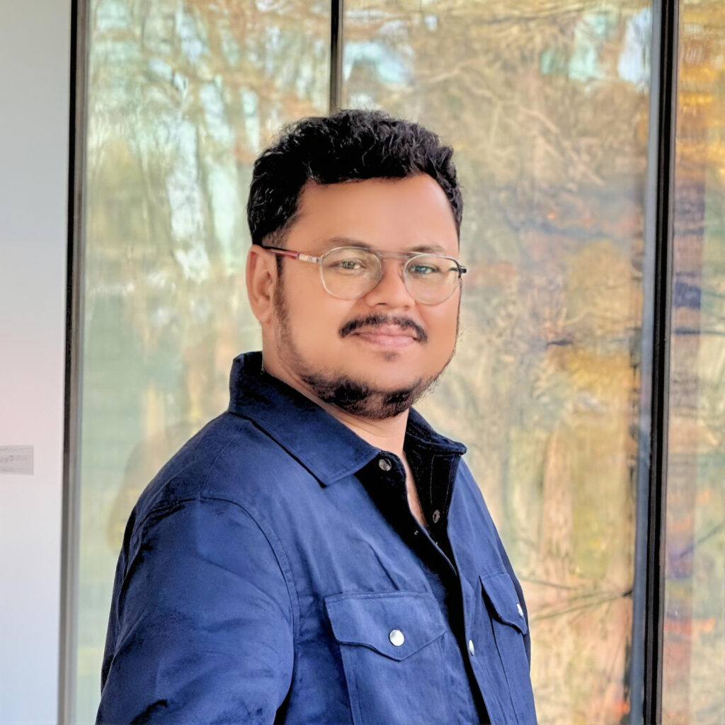 Varun Siddaraju smiling in a professional headshot wearing a blue blazer