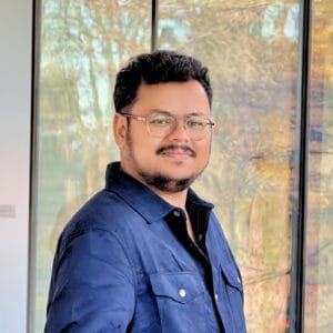 Varun Siddaraju smiling in a professional headshot wearing a blue blazer