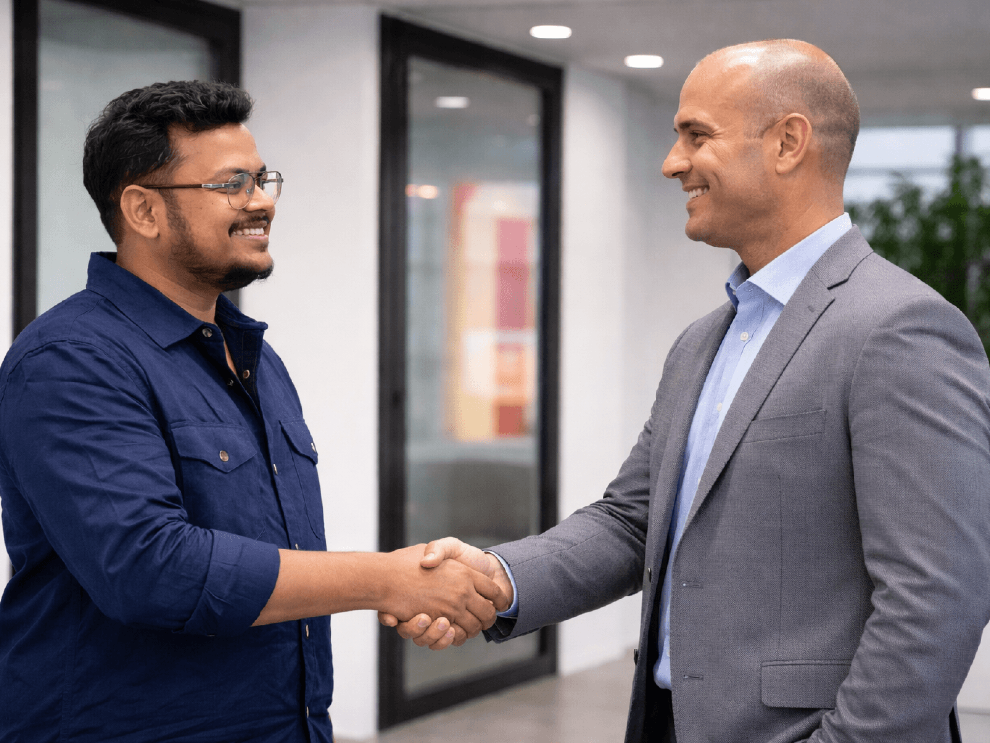 Varun Siddaraju engaging in a professional meeting and handshake during a business discussion.