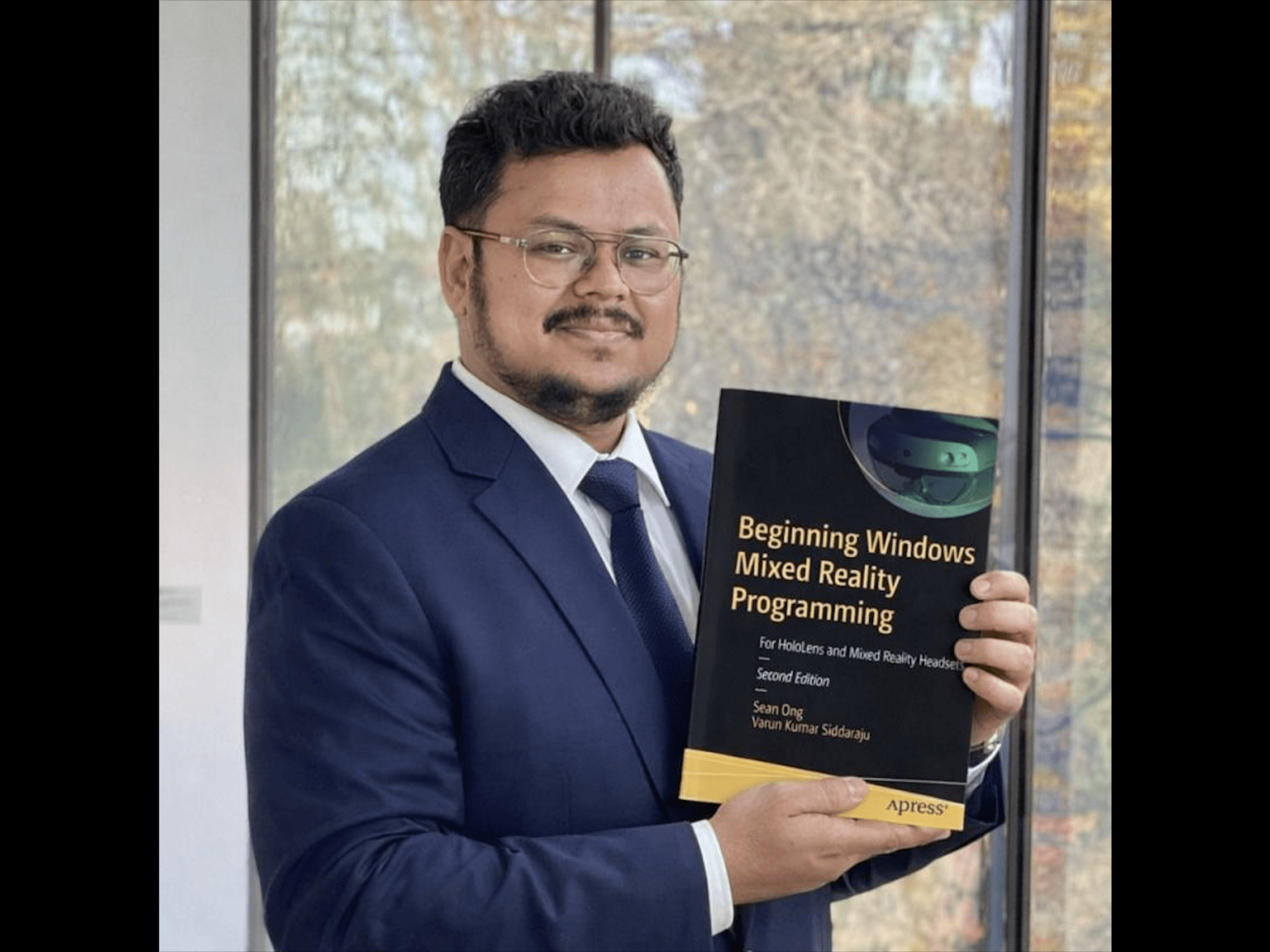 Varun Siddaraju holding the book Beginning Windows Mixed Reality Programming, showcasing his work in XR and mixed reality development.