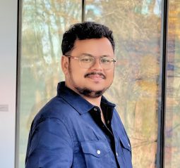 Varun Siddaraju smiling in a professional headshot wearing a blue blazer